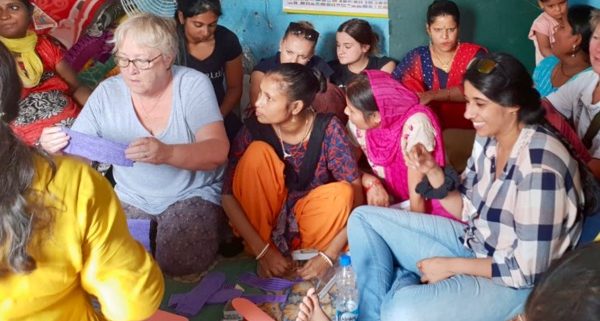 Terryl demonstrating sewing sanitary pads in slum in Delhi